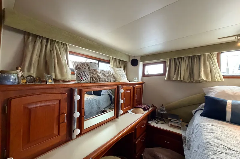 Slide: The Image of Cozy 1989 Californian Aft Cabin interior with wooden cabinetry and decorative pillows. - 42