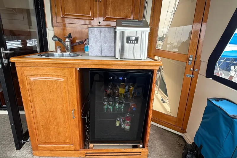 Slide: The Image of 1989 Californian Aft Cabin interior with wooden cabinetry, sink, and mini fridge. - 16