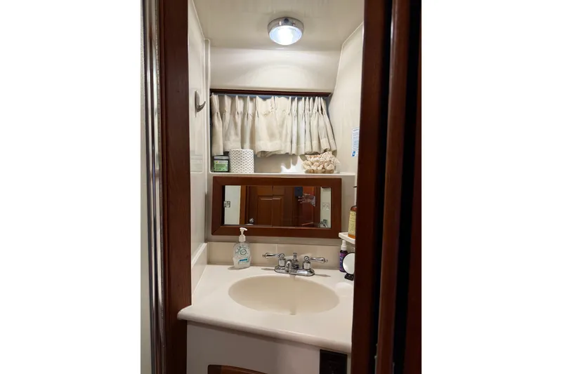 Slide: The Image of 1989 Californian Aft Cabin bathroom with sink, mirror, and toiletries. - 45