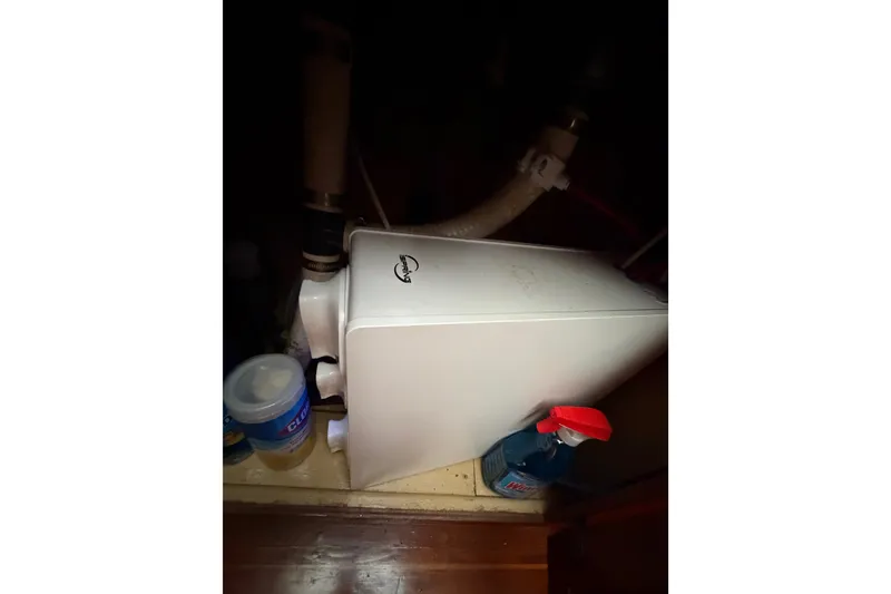 Slide: The Image of 1989 Californian Aft Cabin plumbing with cleaning supplies and pipes. - 26