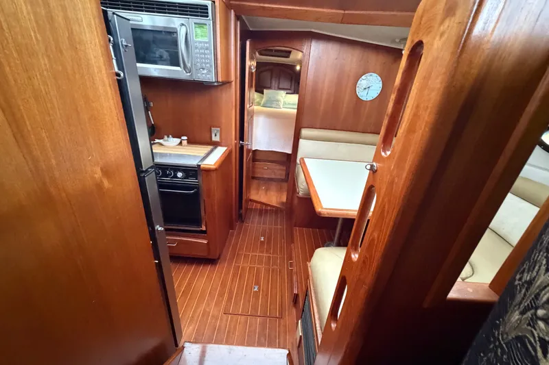 Slide: The Image of 1989 Californian Aft Cabin interior with wood finish, kitchenette, and dining area. - 23
