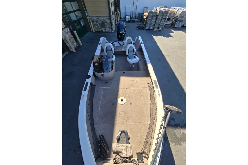Slide: The Image of 2008 Crestliner 1850 Fish Hawk SC boat with spacious deck and seating, parked outdoors. - 5
