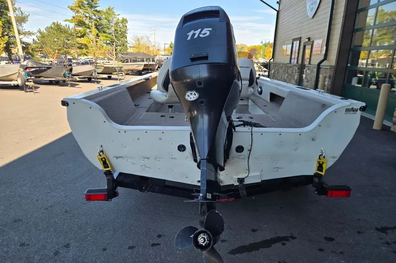 Slide: The Image of 2008 Crestliner 1850 Fish Hawk SC boat with 115 HP outboard motor, parked outdoors. - 2