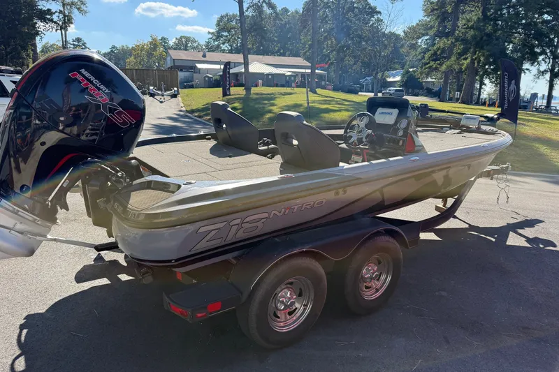 Slide: The Image of 2024 Nitro Z18 boat with Mercury Pro XS engine on a trailer, parked outdoors. - 2