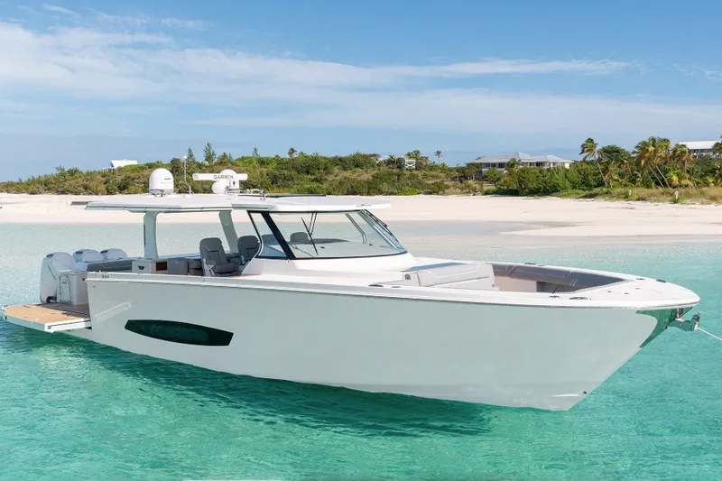 The Image of 2027 Regal 50 SAV yacht anchored in clear turquoise waters near a sandy beach. - 0