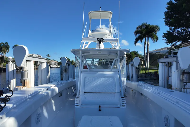 Slide: The Image of 2017 SeaHunter 41 Tournament boat docked, featuring spacious deck and tower, surrounded by palm trees. - 20