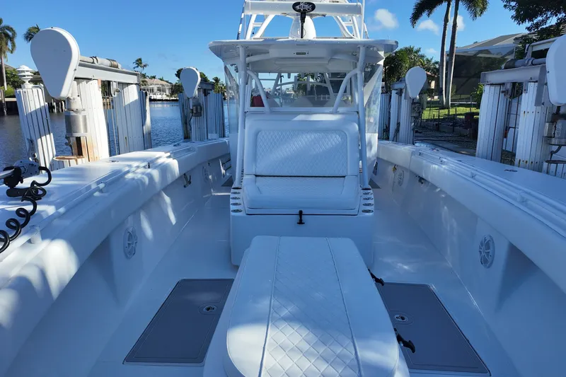 Slide: The Image of 2017 SeaHunter 41 Tournament boat with spacious deck and seating, docked by palm trees. - 21