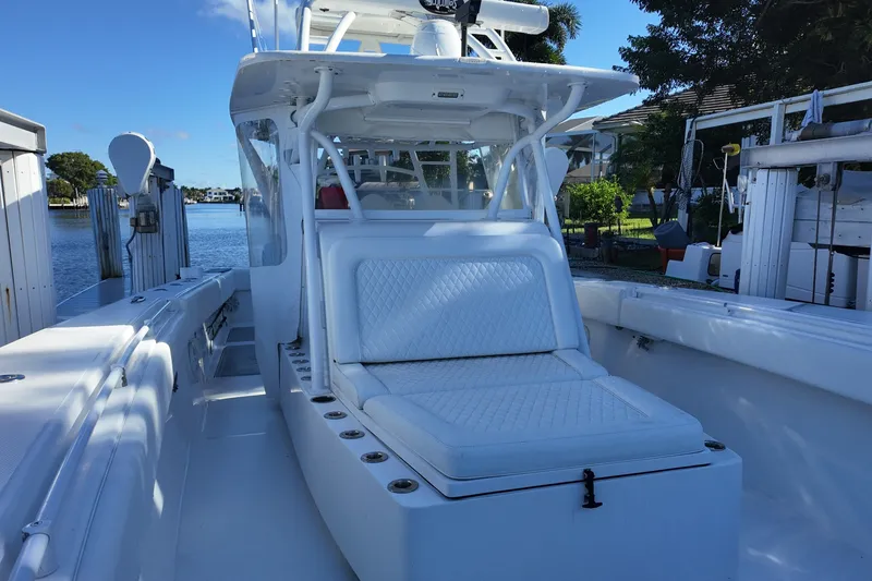 Slide: The Image of 2017 SeaHunter 41 Tournament boat with white seating, docked by a serene waterfront. - 17