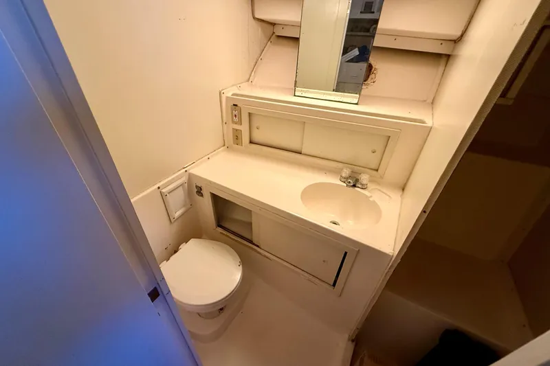 Slide: The Image of 1979 Bertram 35 Flybridge bathroom with sink, toilet, and mirror. - 31
