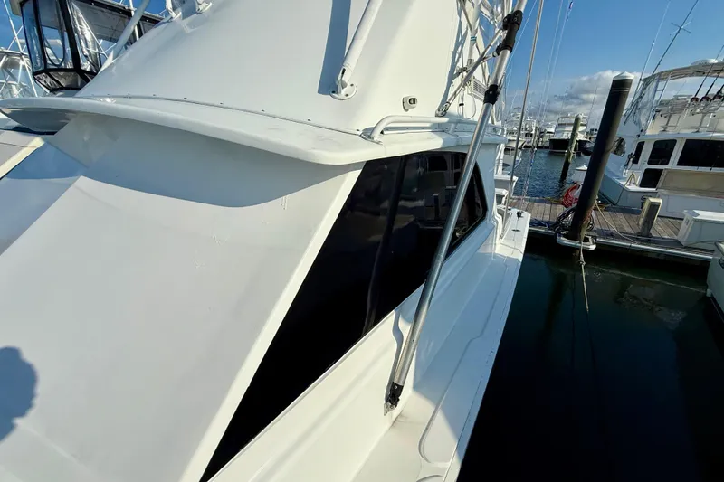 Slide: The Image of 1979 Bertram 35 Flybridge yacht docked at marina, showcasing sleek design and structure. - 13