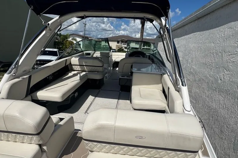 Slide: The Image of 2021 Regal 29 OBX boat interior with beige seating and canopy under blue sky. - 4