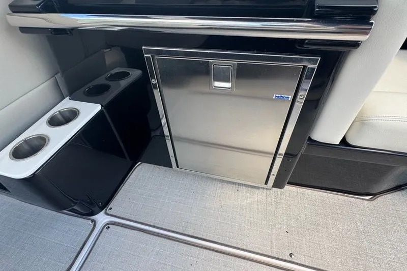 Slide: The Image of 2021 Regal 29 OBX boat interior with stainless steel fridge and cup holders. - 19
