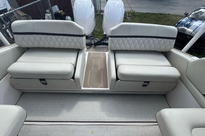 Slide: The Image of 2021 Regal 29 OBX boat interior with dual cushioned seats and outboard motors. - 22