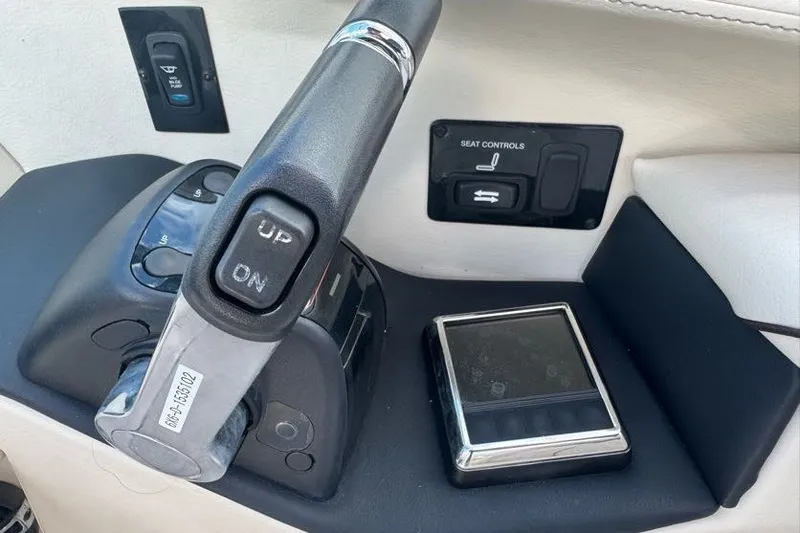 Slide: The Image of 2021 Regal 29 OBX boat controls with throttle and seat adjustment panel. - 13