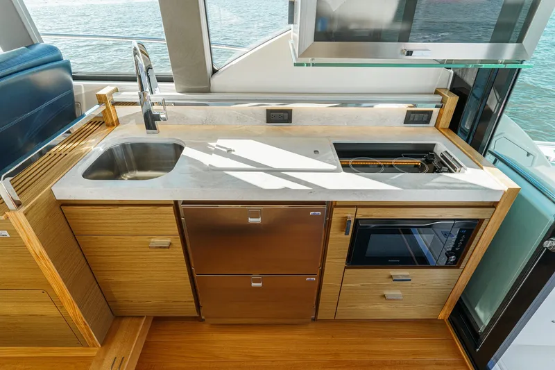 Slide: The Image of Modern kitchen in 2021 Tiara C 44 Coup yacht with sink, stove, and microwave. - 18