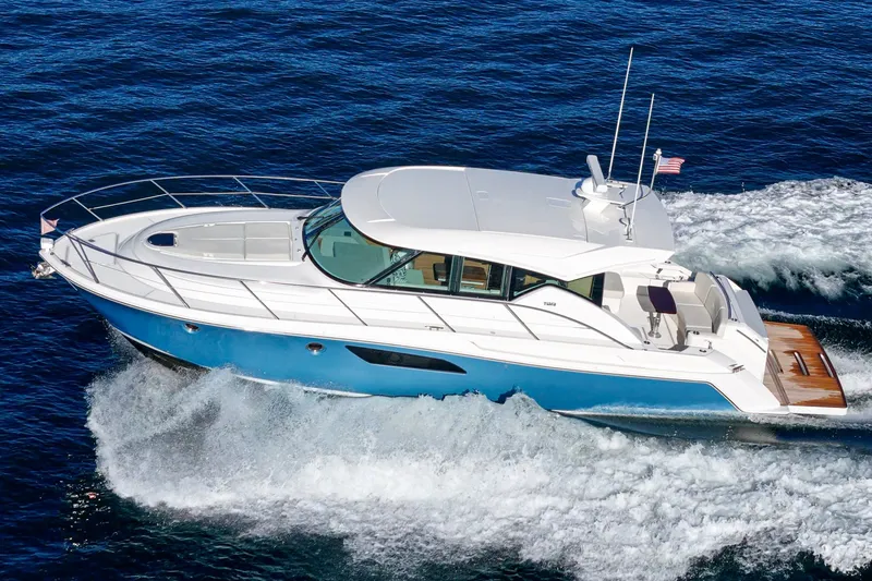Slide: The Image of 2021 Tiara C 44 Coup yacht cruising on open blue water. - 64