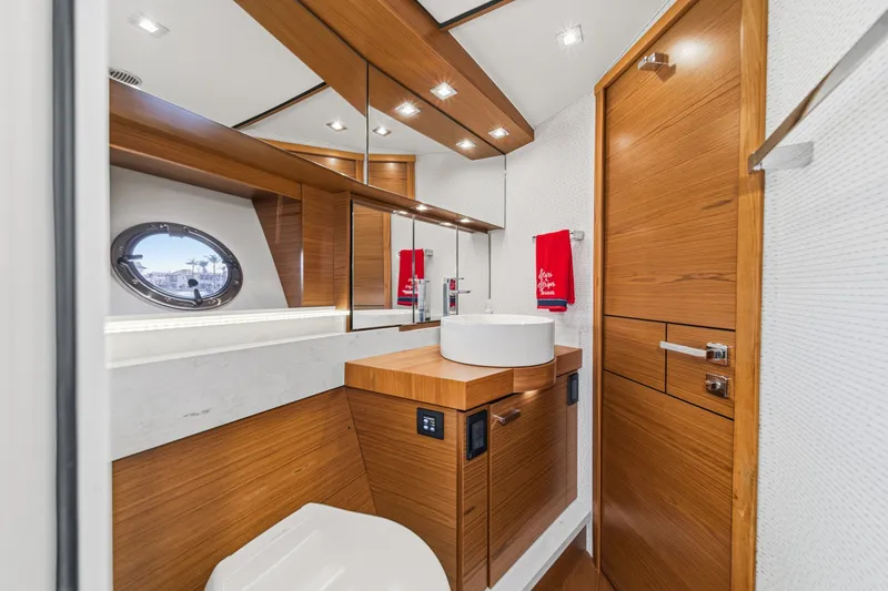 Slide: The Image of Luxurious 2021 Tiara C 44 Coup yacht bathroom with modern wood accents and porthole window. - 35