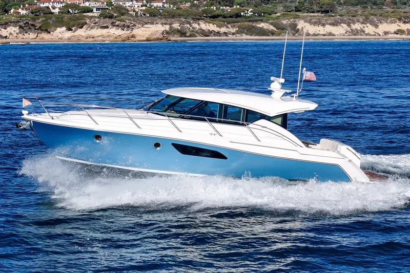 Slide: The Image of 2021 Tiara C 44 Coup yacht cruising on blue ocean near scenic coastline. - 63