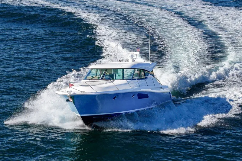 Slide: The Image of 2021 Tiara C 44 Coup yacht cruising on open water, creating a dynamic wake. - 67