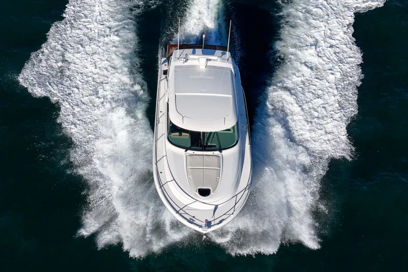 Slide: The Image of 2021 Tiara C 44 Coup yacht cruising on open water, aerial view. - 69