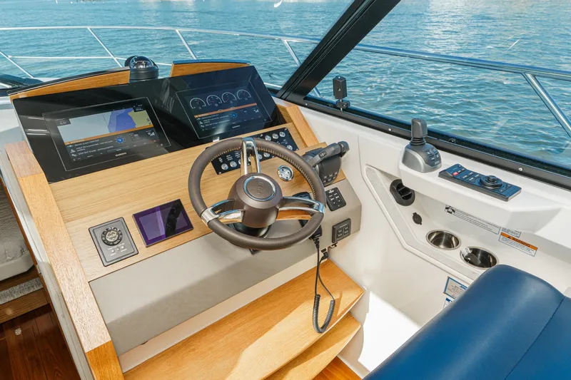 Slide: The Image of Helm of 2021 Tiara C 44 Coup yacht with modern navigation controls and steering wheel. - 24