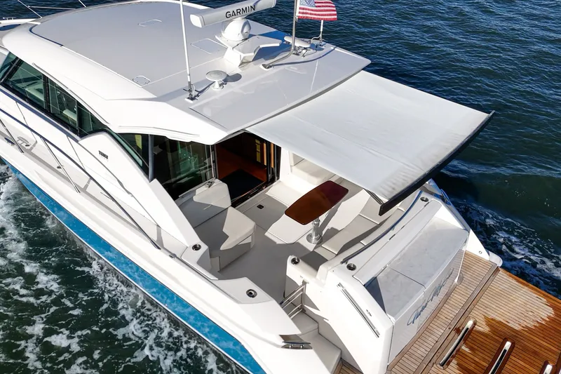 Slide: The Image of 2021 Tiara C 44 Coup yacht with sunshade, cruising on water. - 61