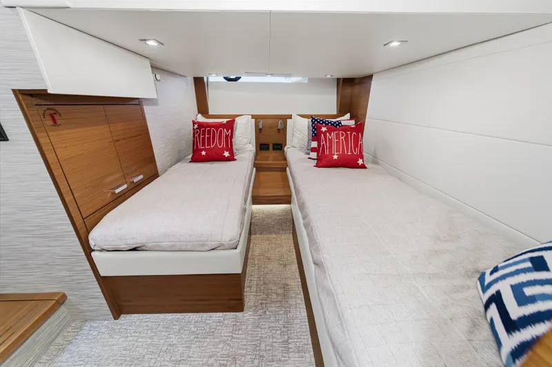 Slide: The Image of Interior of 2021 Tiara C 44 Coup yacht with twin beds and patriotic pillows. - 41