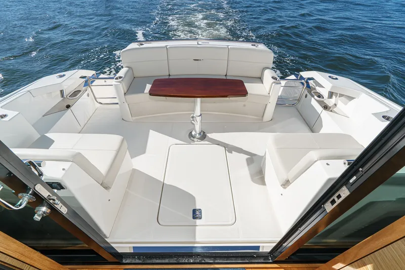 Slide: The Image of 2021 Tiara C 44 Coup yacht deck with seating and wooden table on open water. - 7