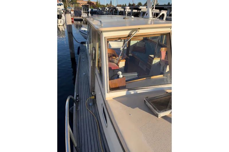 Slide: The Image of Covey Island Spencer Lincoln 1997 boat docked at marina, showcasing cabin and deck details. - 31