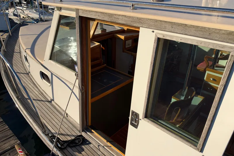 Slide: The Image of Covey Island Spencer Lincoln 1997 boat with open cabin door, showcasing wooden interior. - 34