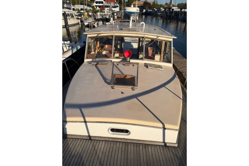 Slide: The Image of 1997 Covey Island Spencer Lincoln boat docked at marina, showcasing cabin and deck. - 28