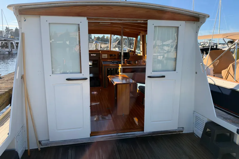 Slide: The Image of Interior view of a 1997 Covey Island Spencer Lincoln boat, showcasing wooden finishes and seating. - 37