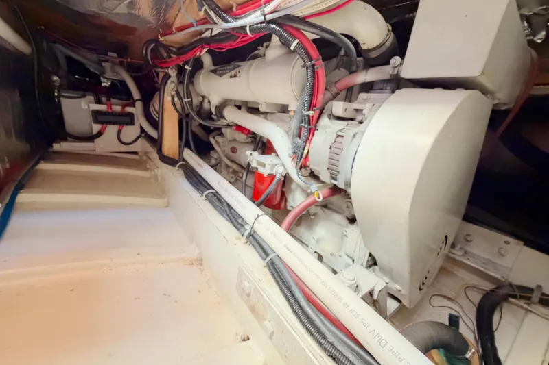 Slide: The Image of Engine room of a 1997 Covey Island Spencer Lincoln boat, showcasing mechanical components and wiring. - 23