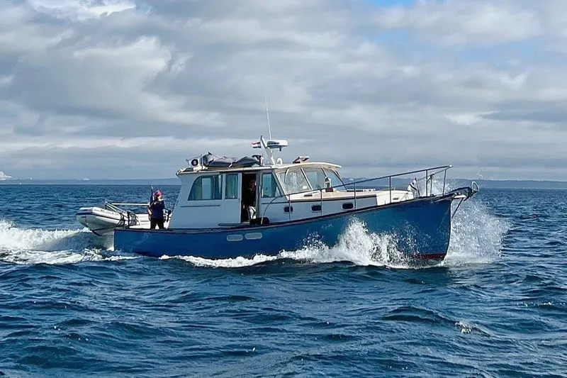 The Image of Covey Island Spencer Lincoln 1997 boat cruising on open water under cloudy skies. - 0