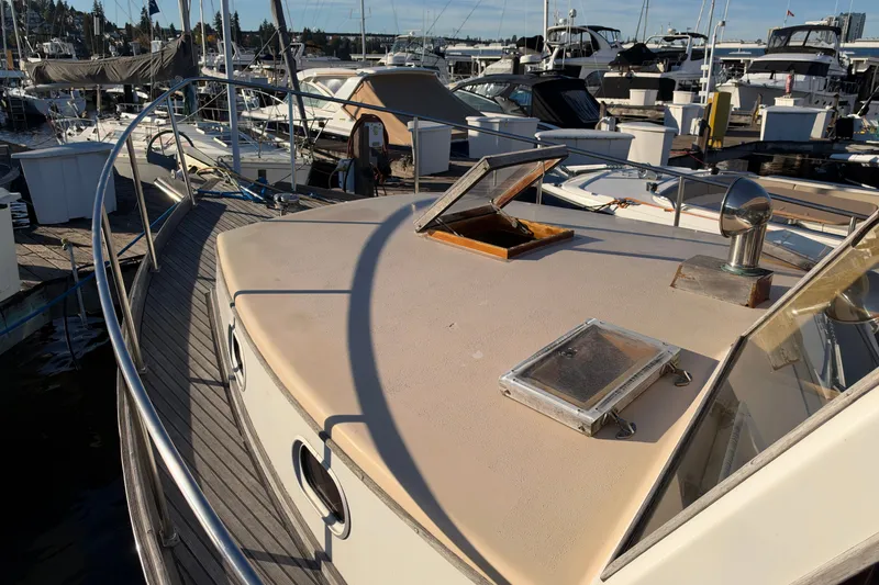 Slide: The Image of Covey Island Spencer Lincoln 1997 boat docked at marina, featuring open hatch and sleek design. - 32