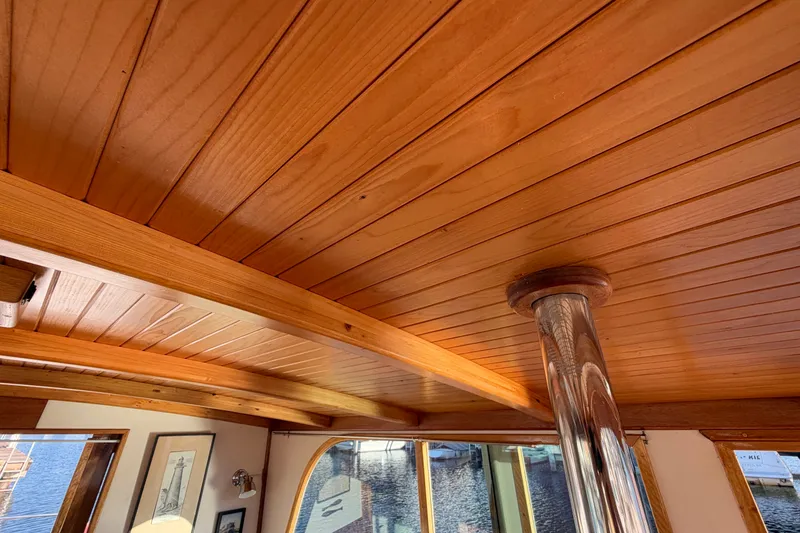 Slide: The Image of Wooden interior ceiling of a 1997 Covey Island Spencer Lincoln boat, featuring polished metal support. - 22