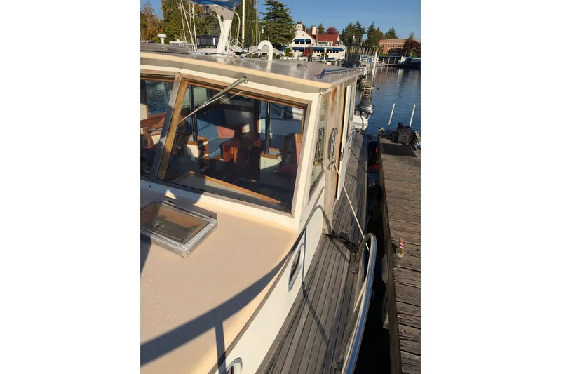 Slide: The Image of 1997 Covey Island Spencer Lincoln boat docked, showcasing cabin and deck details. - 30