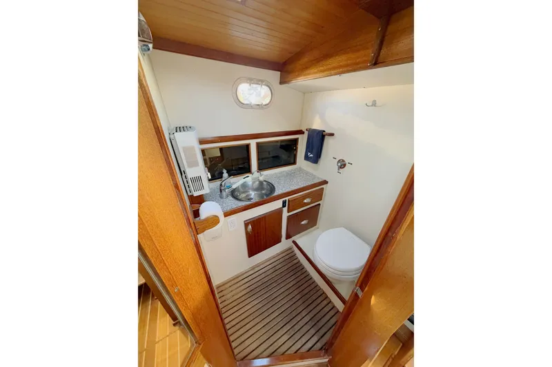 Slide: The Image of 1997 Covey Island Spencer Lincoln boat bathroom with wooden accents and compact design. - 14