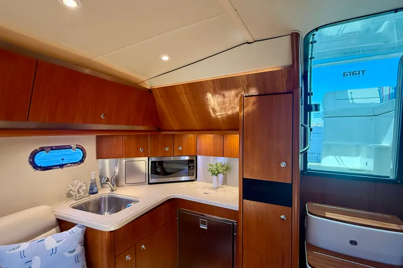 Slide: The Image of Interior of 2006 Tiara Yachts 3600 Sovran, featuring a modern kitchenette with wood cabinetry. - 20