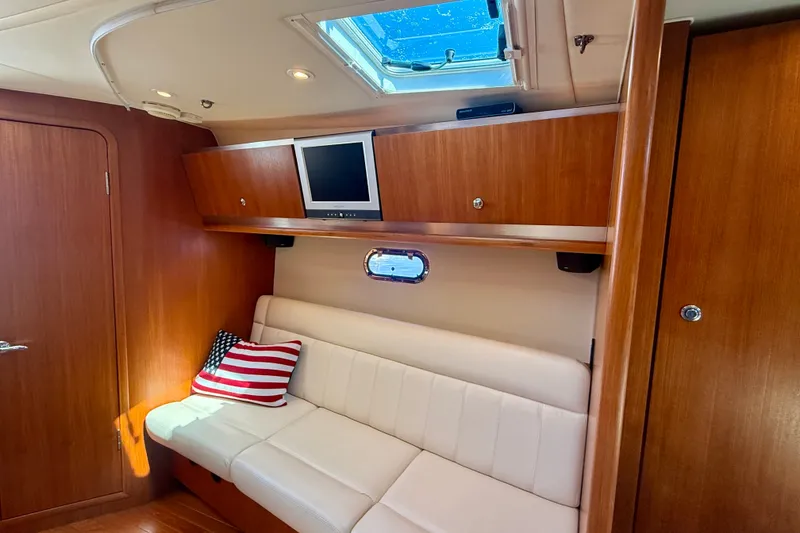 Slide: The Image of Interior of 2006 Tiara Yachts 3600 Sovran with sofa, TV, and American flag pillow. - 32