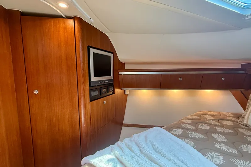 Slide: The Image of Luxurious 2006 Tiara Yachts 3600 Sovran cabin with wood paneling and cozy bedding. - 30