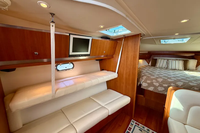 Slide: The Image of 2006 Tiara Yachts 3600 Sovran interior with cozy seating, TV, and elegant bedding. - 34