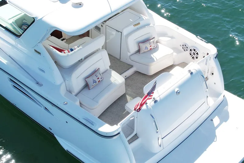 Slide: The Image of 2006 Tiara Yachts 3600 Sovran, luxurious white deck, American flag, nautical cushions. - 10