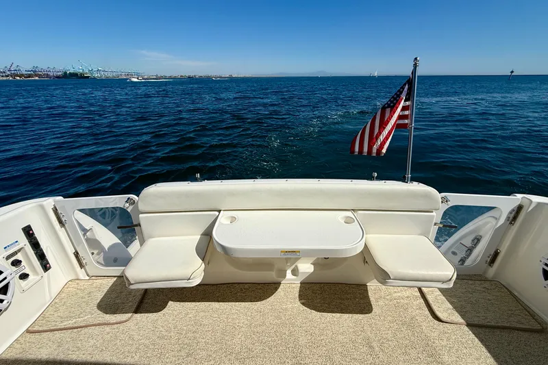 Slide: The Image of 2006 Tiara Yachts 3600 Sovran deck with seating, table, and American flag on open water. - 37