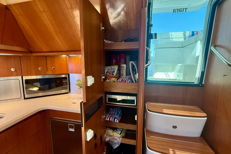 Slide: The Image of 2006 Tiara Yachts 3600 Sovran interior kitchen with wooden cabinetry and modern appliances. - 27