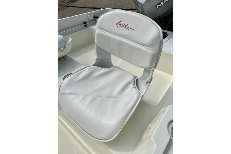 Slide: The Image of White boat seat on a 1995 Wahoo 1650, featuring a sleek design and logo. - 22