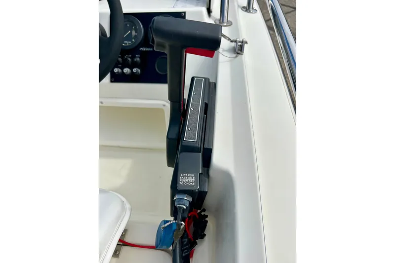 Slide: The Image of Control panel of a 1995 Wahoo 1650 boat, featuring throttle and steering components. - 16