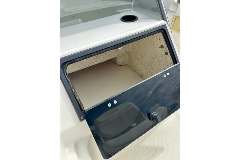Slide: The Image of Open storage compartment on a 1995 Wahoo 1650 boat, featuring a black door. - 21