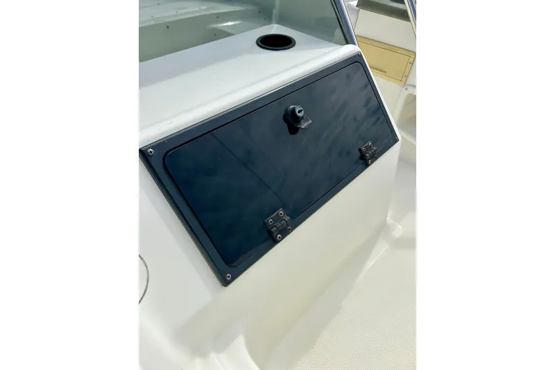 Slide: The Image of 1995 Wahoo 1650 boat dashboard with black panel and storage compartment. - 20