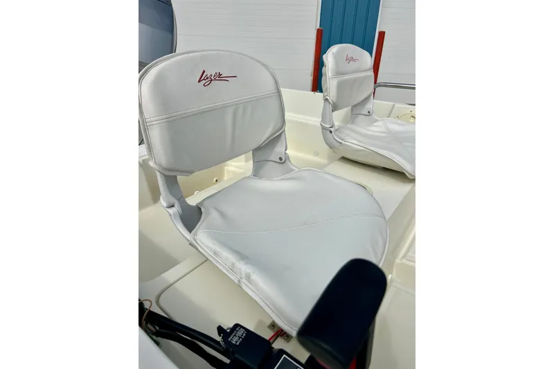 Slide: The Image of White leather seats on a 1995 Wahoo 1650 boat, featuring "Lazer" branding. - 18